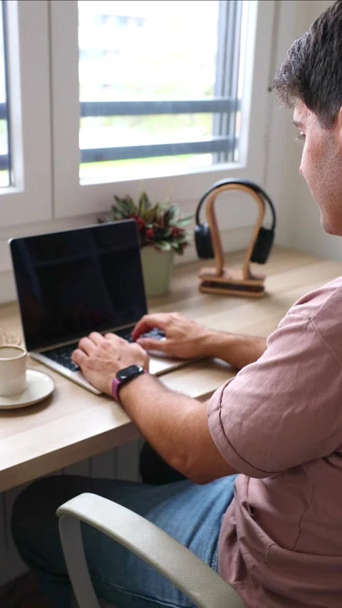 Vertical Young Hispanic man teleworking from home typing on a laptop computer Stock Footage 319027708