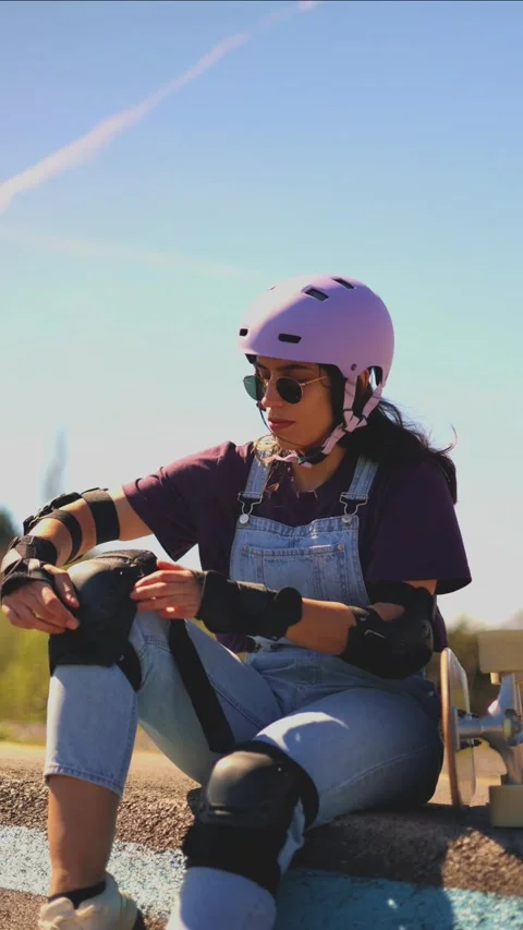 Vertical Young latin skater adjusting her protective gear Stock Footage 308742895