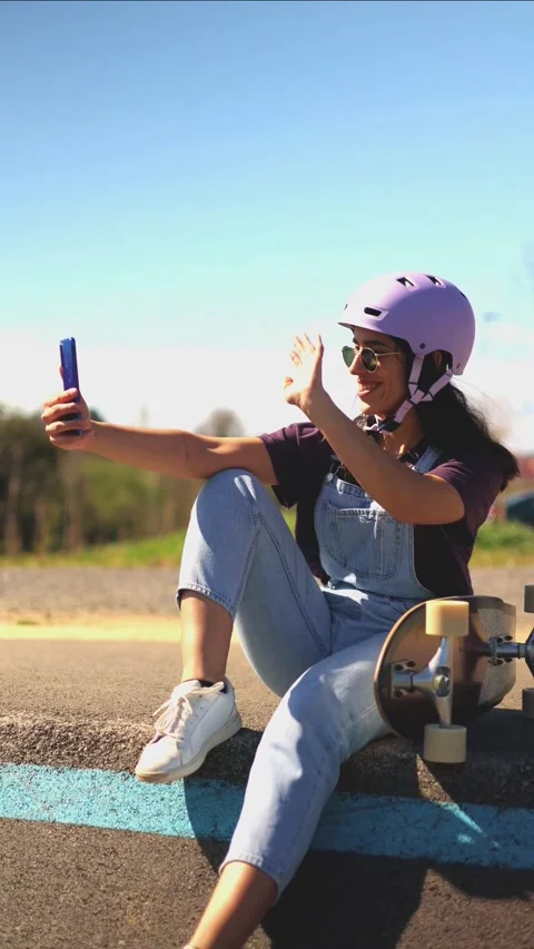 Vertical Young latin skater making a video call on a pump track Stock Footage 308742889