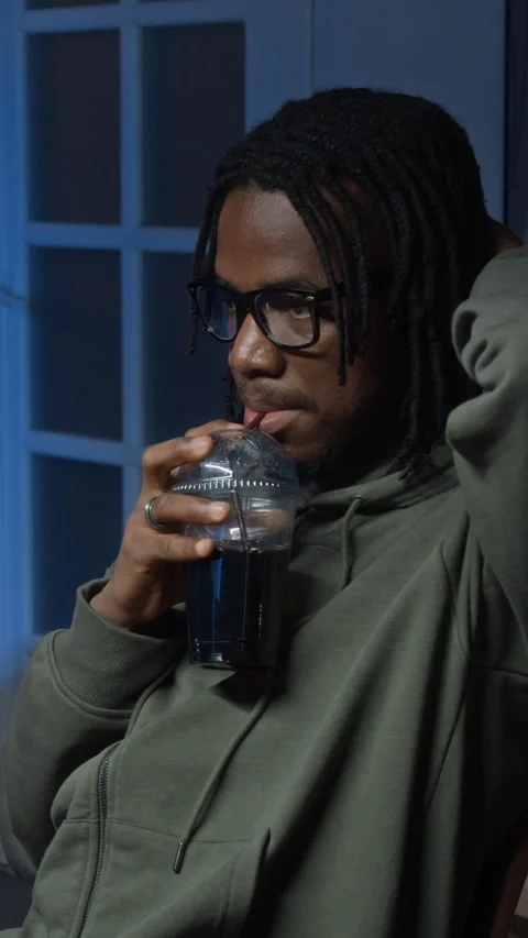 Vertical of Young Male Developer Drinking Soda while Working Remotely at Home Stock Footage 328285921