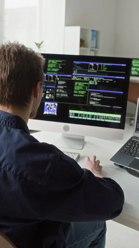 Vertical of Young Male IT Developer Coding on Computer and Laptop in Office 스톡 동영상 330131214