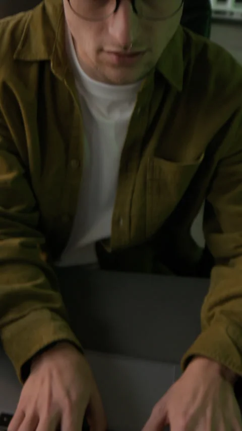 Vertical of Young Male Programmer Typing on Laptop in Office in Evening Stock Footage 299680738