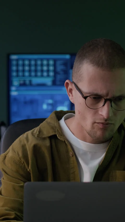 Vertical of Young Male Programmer Working with Program Coding in Dark Office Stock Footage 292900627