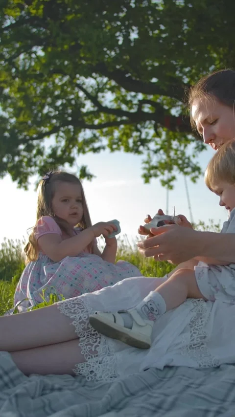 Vertical of Young Mom puts sandals on her little one-year-old daughter. Stock Footage 276925581