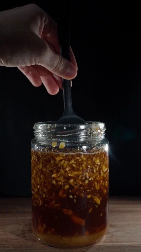 Vertical Zoom In Hand Stirring Fermented Ginger Honey Ladle Slow Motion Stock Footage 324921667