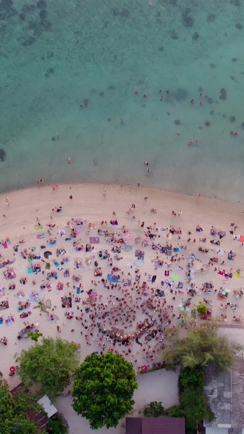 Vertical.Aerial video of crowds of people dancing and having fun on a zen beach Stock Footage 292966758