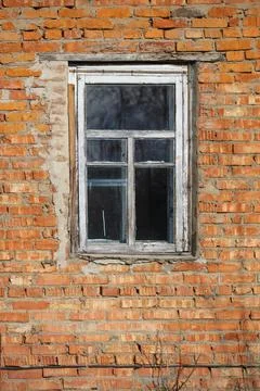 Vertically brick wall with a window in an old rustic frame. Foto stock