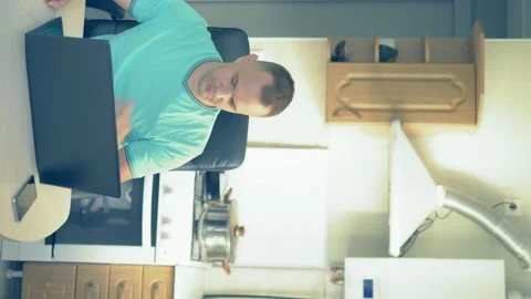 Vertically. man uses laptop while sitting at home in the kitchen Stock Footage 138251019