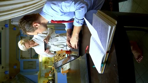 Vertically. a man works at home in the kitchen, his wife in the kitchen Stock Footage 128516001
