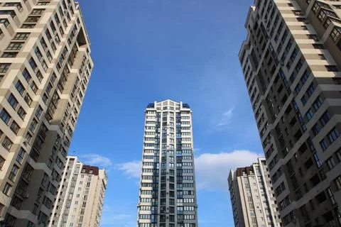 Vertically shot view of tall structures with repeating reflective facade designs 스톡 사진