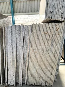 Vertically stacked granite slabs in a factory. Stock Photos