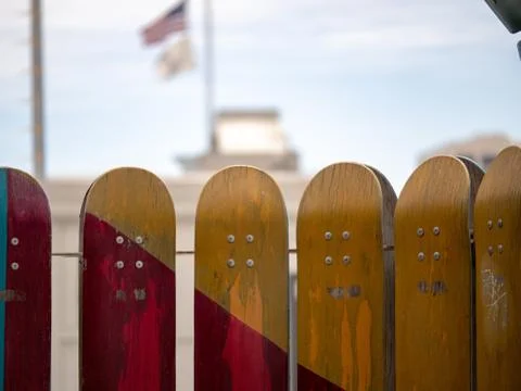 Vertically standing red and yellow skateboards hung as if they were a barrier Stock Photos