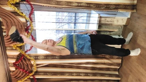 Vertically video. A man in training at home with shakes muscles with an iron 库存影片 142015900
