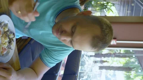 Vertically. young hungry man eating potato casserole in a cafe. copy space Stock Footage 138302248