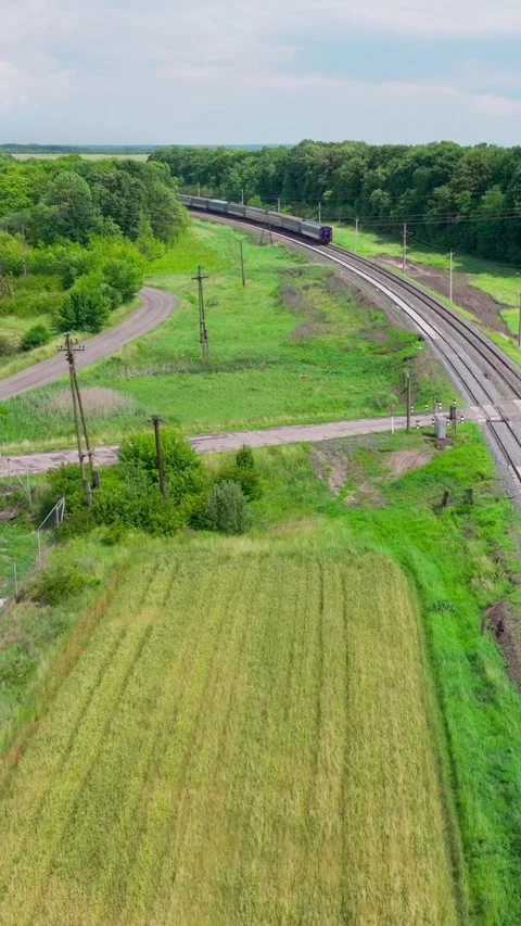 Vertical.Passenger train moves along rural railway passing railway  aerial view Stock Footage 321768424