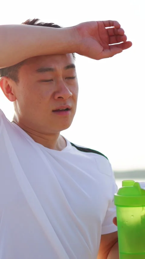 A Very Active Man Happily Enjoying a Refreshing Cold Drink While Outdoors in Stock Footage 314151628
