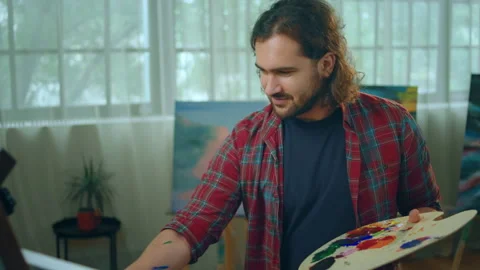 A very artsy looking guy is ecstatic at seeing how his art work painting canvas Stock Footage 231855013