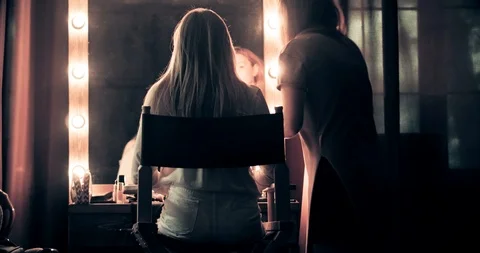 Very attractive blonde master does her hair, put make-up on her face, makes Stock Footage 99509309