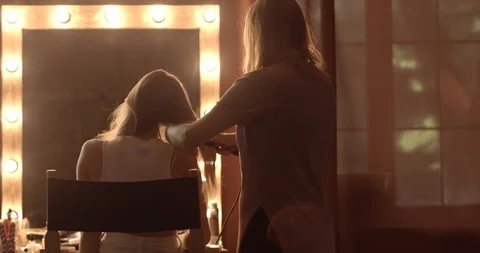 Very attractive blonde master does her hair, put make-up on her face, makes Stock Footage 99509490