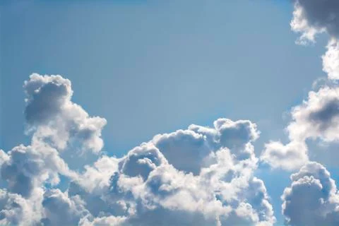 Very beautiful voluminous white clouds. Solar rays pass through the clouds. B Stock Photos