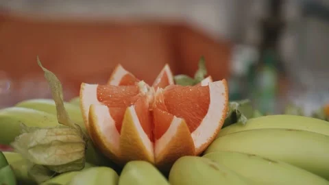 A very beautifully sliced grapefruit fruit stands on a plate on a tole Stock Footage 191918852