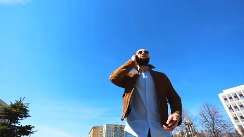 A very busy man is using two phones at the same time. With one he is talking on Stock Footage 107343169