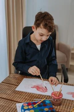 Very charismatic kid does something nice for the fine arts at school Stock Photos