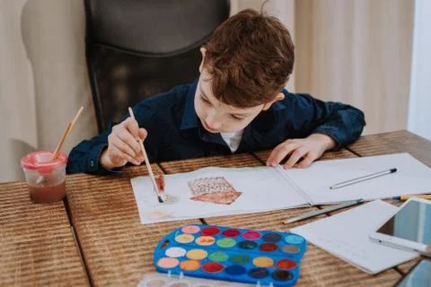 Very charismatic kid does something nice for the fine arts at school Stock Photos