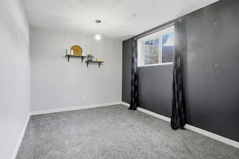 Very clean and empty room with a black wall and a white carpet Stock Photos