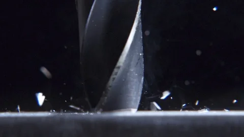 Very close drill drills a sheet metal. Particles are scattered. Slow motion. Stock Footage 128994292