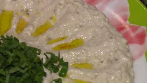 A very close-up on hummus. Hummus with vegetable oil, herbs and vegetables. Stock Footage 88866201