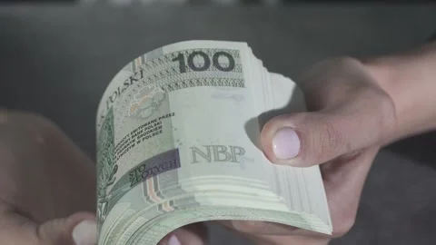 A very close view of young hands holding a bundle of new banknotes and fanning t Vídeo Stock 132488820