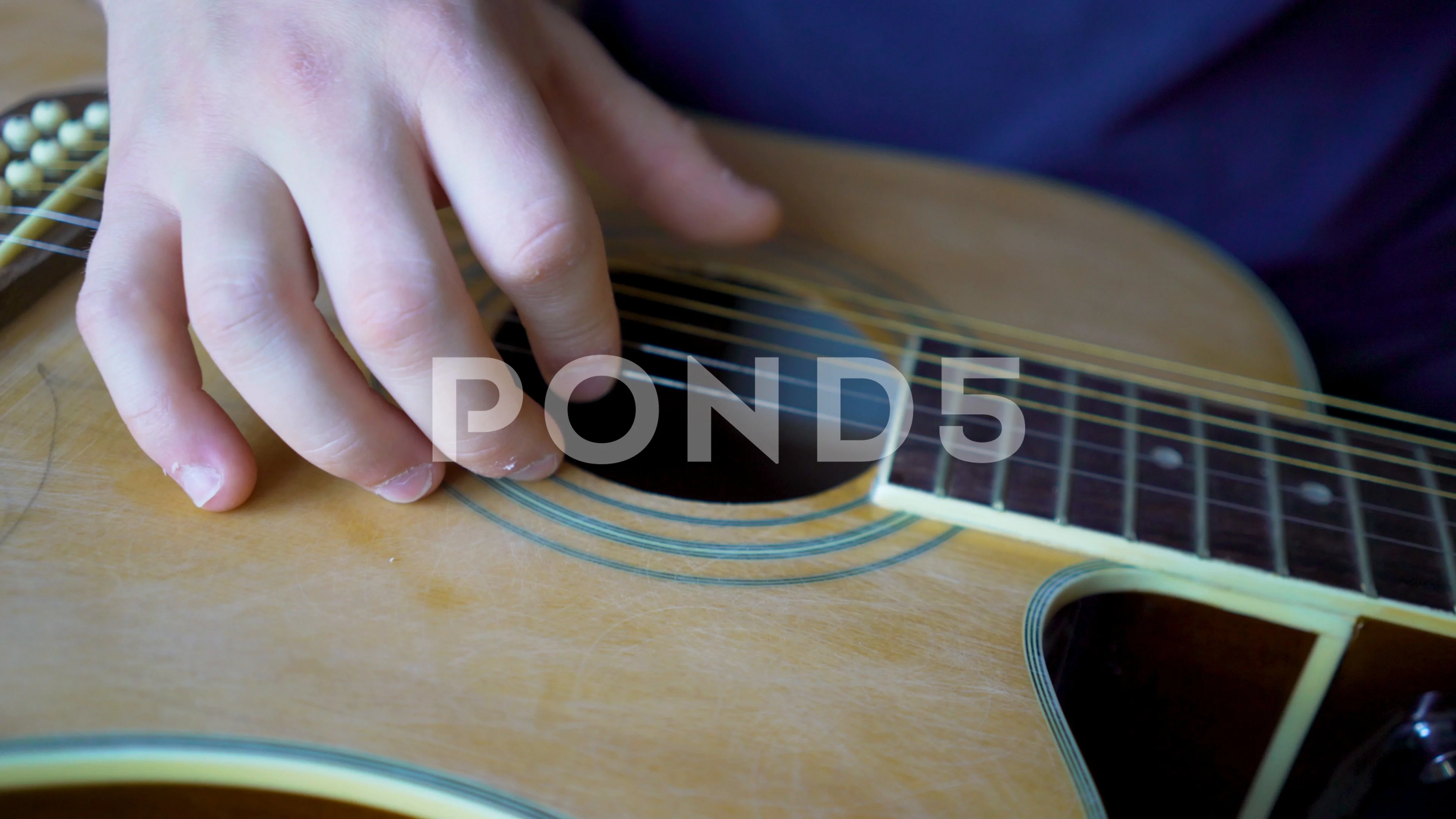 Very closeup on finger plucking the strings on the slide guitar