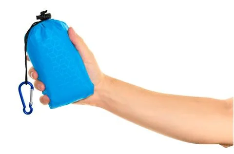 Very compact hand held blue nylon pocket blanket in a drawstring bag with a c Stock Photos