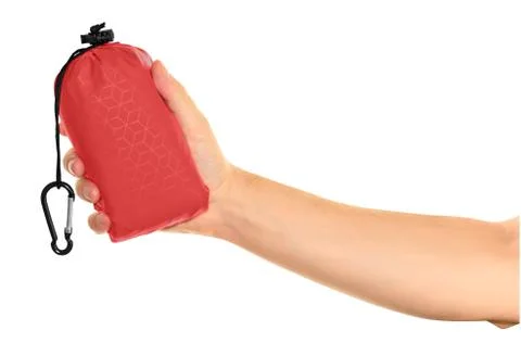 Very compact hand held red nylon pocket blanket in a drawstring bag with a ca Foto stock