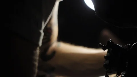 Very dark slide shoot of working tattoo artist on the models leg Stock Footage 93144970