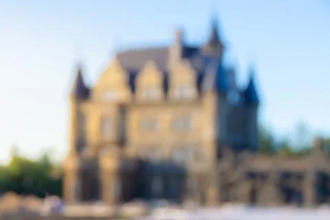 Very defocused castle in the rays of the summer rising or setting sun, blur Stock Photos