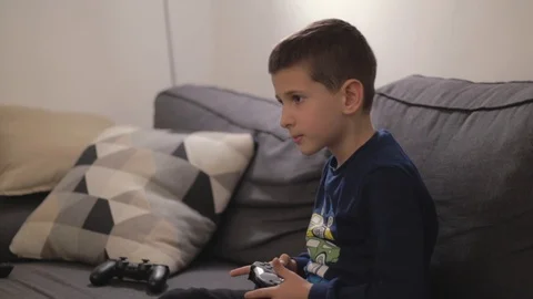 Very determined boy playing video games in livingroom Stock Footage 102416107