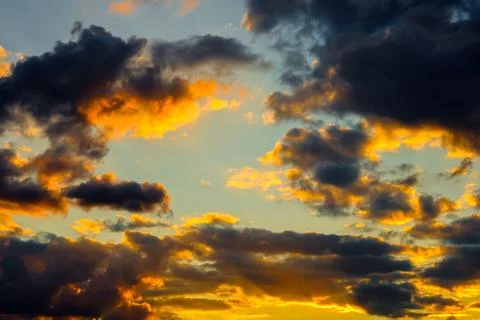 A very dramatic sky full of yellows, blues and oranges. Contrasting clouds Stock Photos