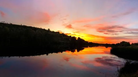 Very dramatic sunset scene. Colours red, orange, violet and reflections in th Stock Photos