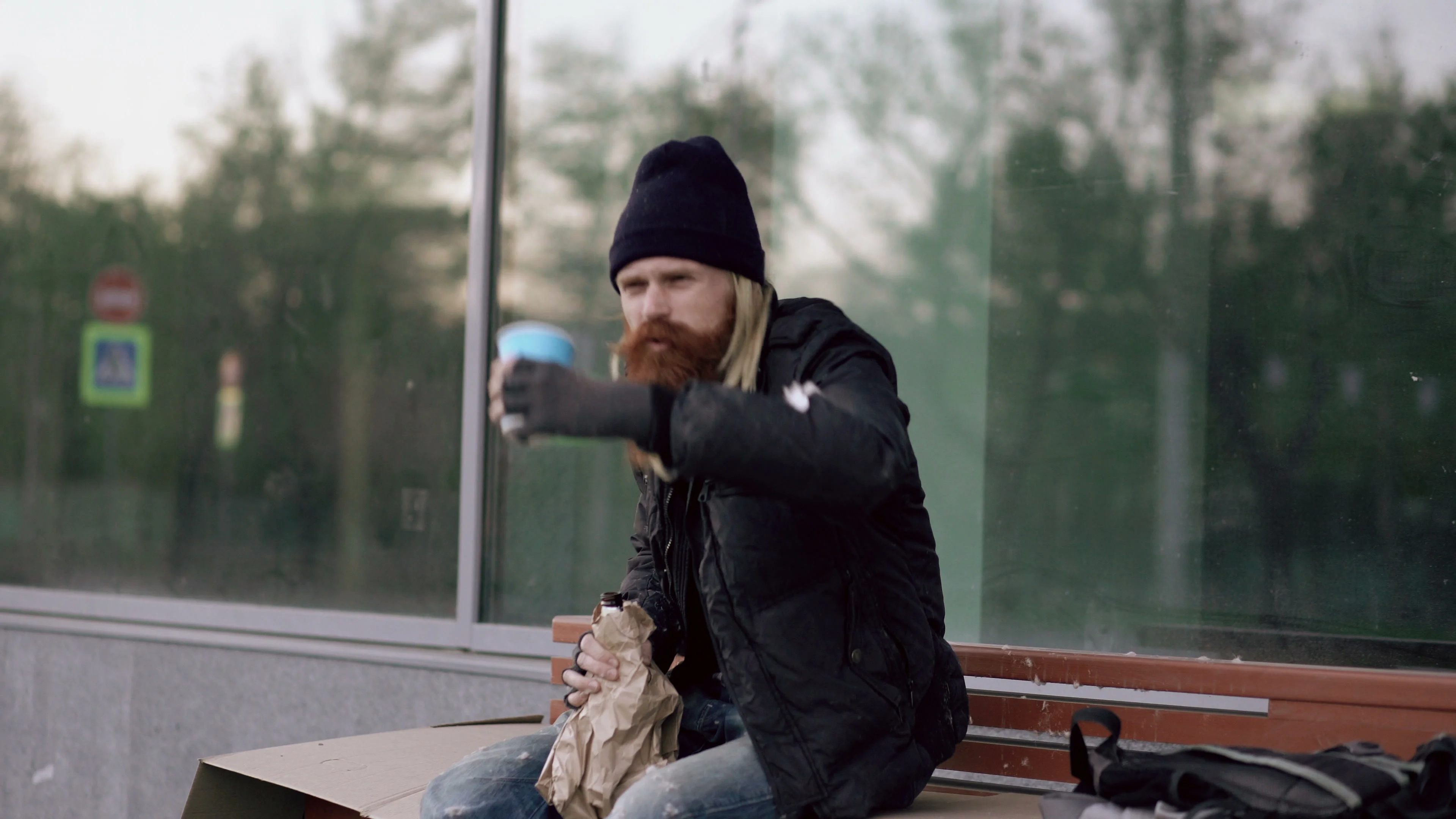 Very drunk homeless man talking to people walking near him and beg for money