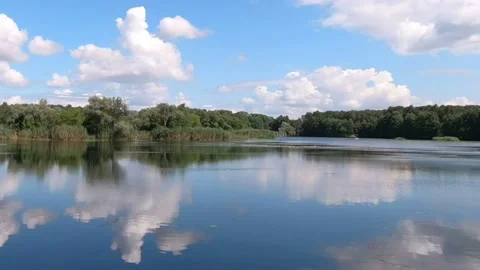 Very fast flying clouds over a forest lake. Stock-Footage 136672173