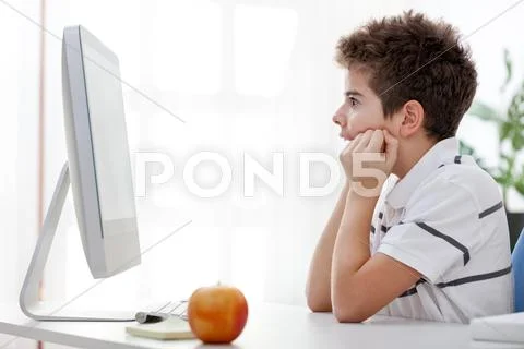 Very focused boy looking at computer screen Stock Photos