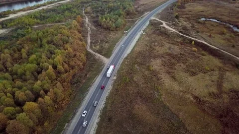 Very high up drone shot of red truck with trailer driving an interstate highway 動画素材 196236395