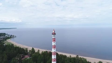 Very high lighthouse in white and red colors standing on the Ladoga coast. Stock Footage 100689424