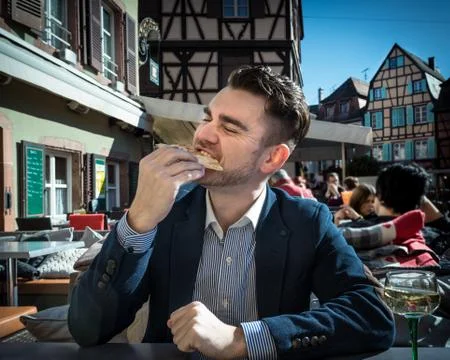 Very hungry man eats pizza in a cafe outdoors Stock Photos