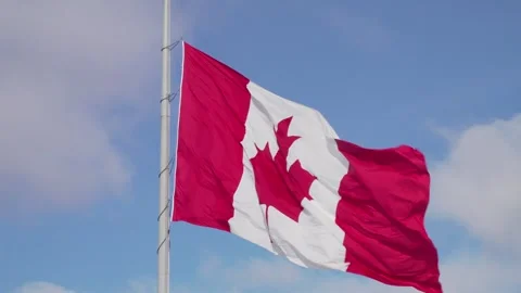 Very Large Canada Flag In 4K Slow Motion Against Blue Sky With Light Clouds Stock Footage 243716224