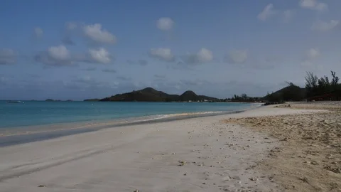 Very long beach of a pristine tropical island with mountains in the background Stock-Footage 126709042