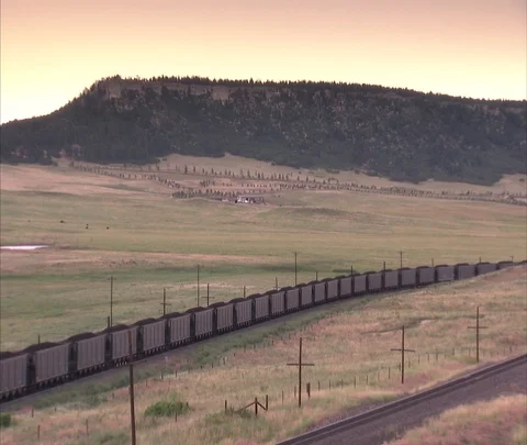 Very long coal train moves across landscape, zoom in to coal cars Stock Footage 86692786