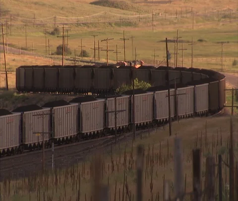 Very long coal train twists and turns across landscape Stock Footage 86692308